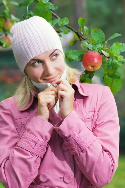 粉红色的外套苹果树附近的年轻女孩 — 图库照片