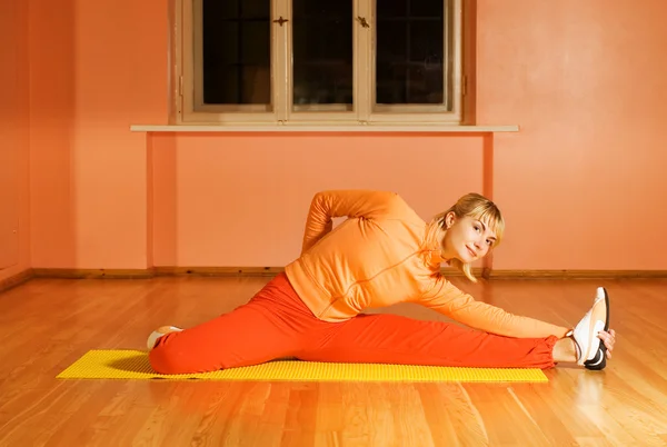 Fitness trainer showes stretching exersise Royalty Free Stock Photos