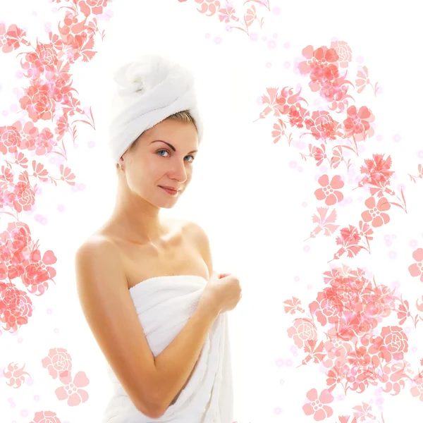 Hermosa chica con toallas de baño y flores a su alrededor — Foto de Stock