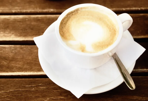 Kaffekopp på träbord (tonade i sepia) — Stockfoto