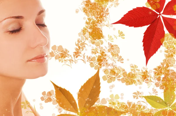 Krásná dívčí tvář a barevné podzimní listí kolem ní — Stock fotografie