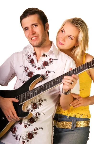 若い音楽家はギターを果たしているし 美しいブロンドの女の子は近くに立って — ストック写真