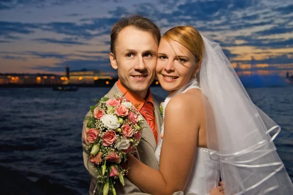 Casado casal perto do rio ao pôr-do-sol — Fotografia de Stock