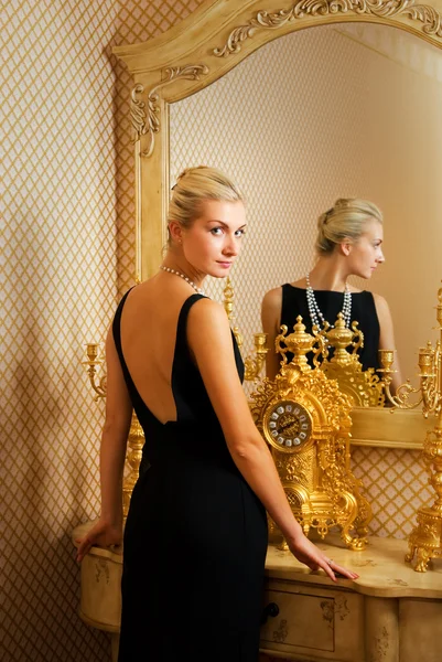 Beautiful blonde girl near luxury the mirror — Stock Photo, Image