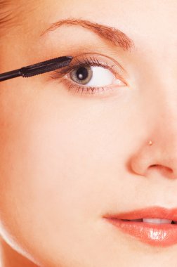 Close-up portrait of a girl applying make-up clipart