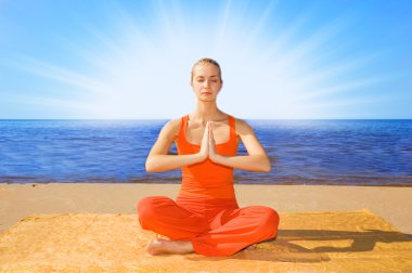 Beautiful girl meditating on the beach clipart