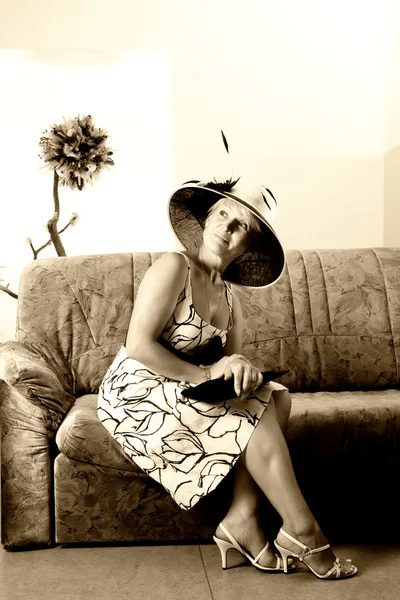 一个优雅的女人在沙发上的棕褐色肖像 — 图库照片