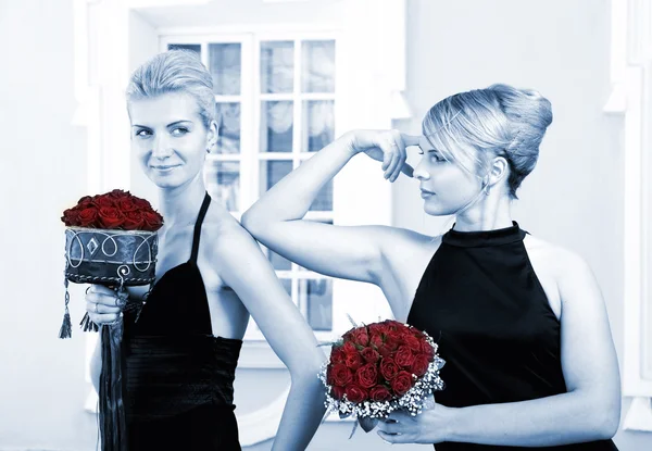 Två vackra flickor med blommor (tonas i blått) — Stockfoto