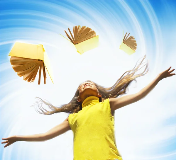 Young happy girl over abstract background and flying books aroun — Stock Photo, Image