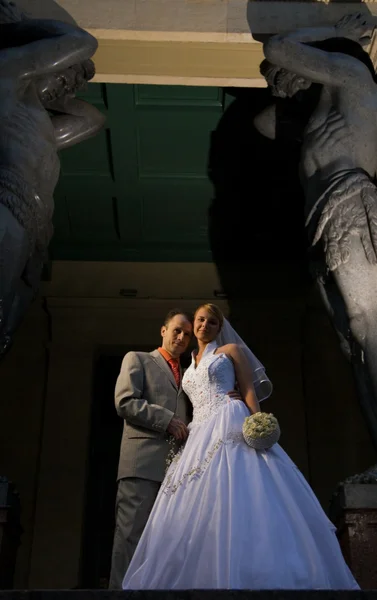 Жених и невеста возле колонн на закате — стоковое фото