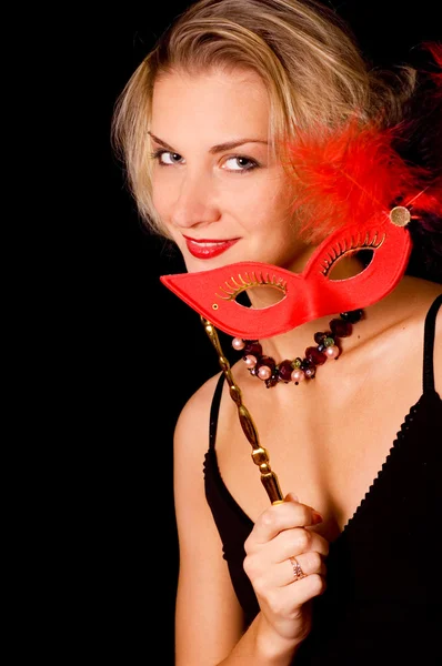 Blond meisje met een carnaval masker geïsoleerd op zwarte achtergrond — Stockfoto