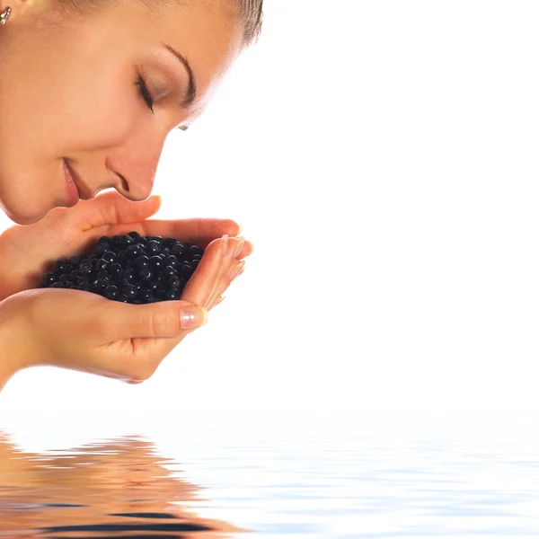 Krásná dívka s hrst borůvky v vykreslený vody — Stock fotografie