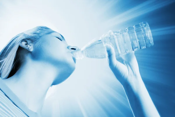 Bella ragazza bionda che beve acqua (tonica in blu ) — Foto Stock
