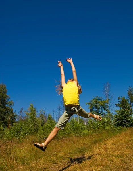 Девушка прыгает по лугу — стоковое фото