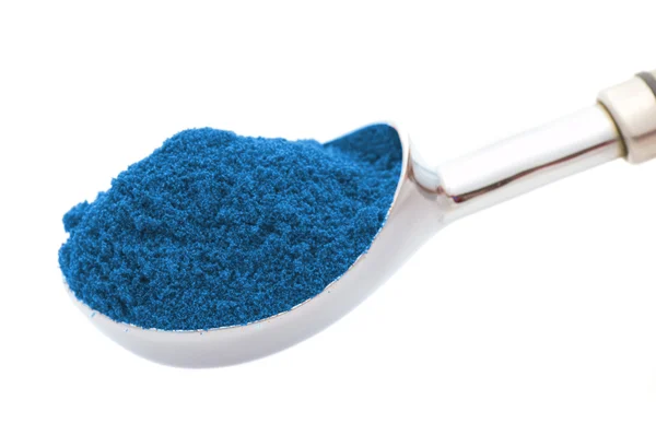 Ασημένιο κουτάλι με μπλε σκόνη που απομονώνονται σε λευκό — Φωτογραφία Αρχείου