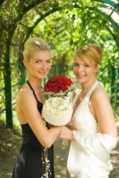 Twe girls mit Blumen in der grünen Gasse — Stockfoto