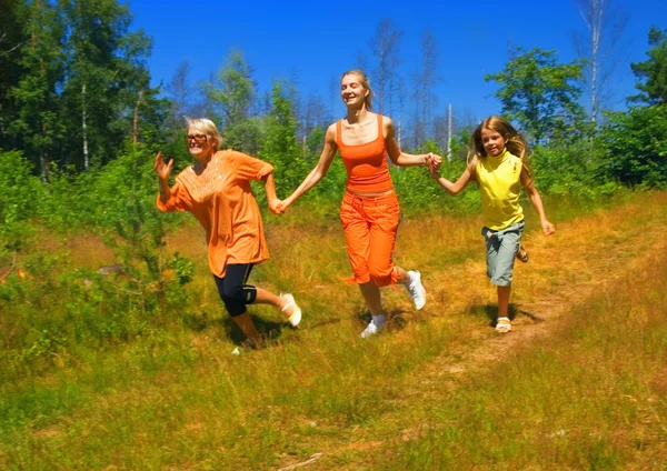 Mãe e duas filhas correndo na floresta — Fotografia de Stock