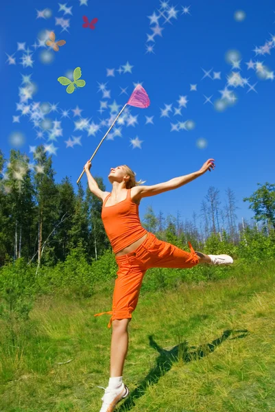 Schöne Mädchen mit einem Netz in der Hand versucht, magischen Hintern zu fangen — Stockfoto