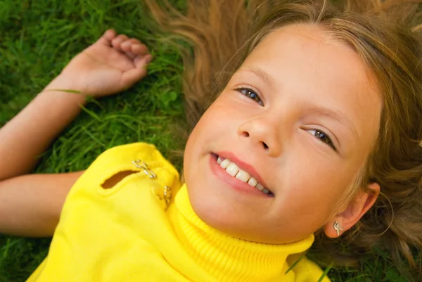 Kleines Mädchen im Gras liegend — Stockfoto