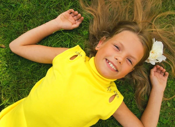 Маленька дівчинка лежить на зеленій траві — стокове фото