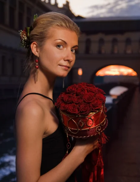 Schöne blonde Mädchen mit einem Bouquet von Rosen bei Sonnenuntergang in der Nähe — Stockfoto