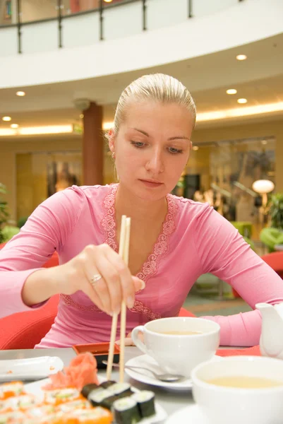 Дівчина їсть суші в ресторані — стокове фото