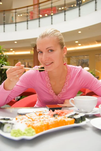 Девушка ест сушин в ресторане — стоковое фото