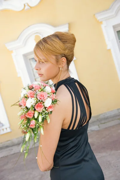 Beautiful redhead girl with a bridal bouquet of roses — Stock Photo, Image
