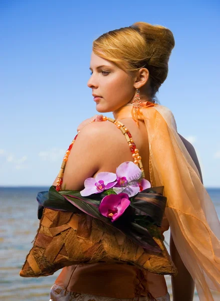 Roodharige meisje op het strand met florale handtas — Stockfoto
