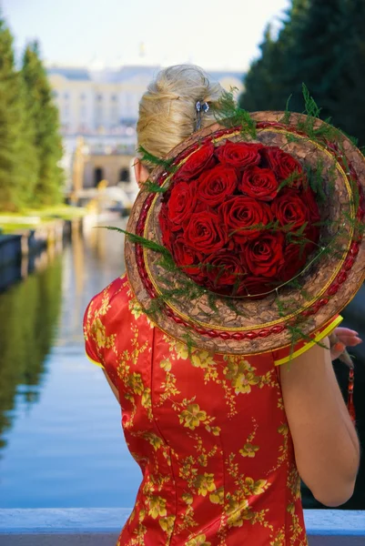 Ragazza bionda con un mazzo di rose rosse — Foto Stock