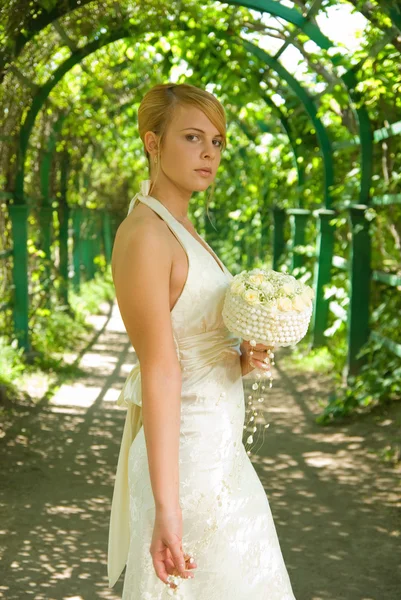 Attraente ragazza rossa con un bouquet da sposa di rose bianche — Foto Stock