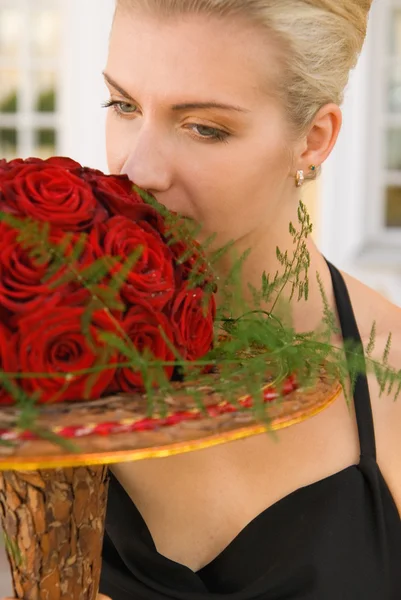 Menina loira bonita com um buquê de rosas vermelhas — Fotografia de Stock