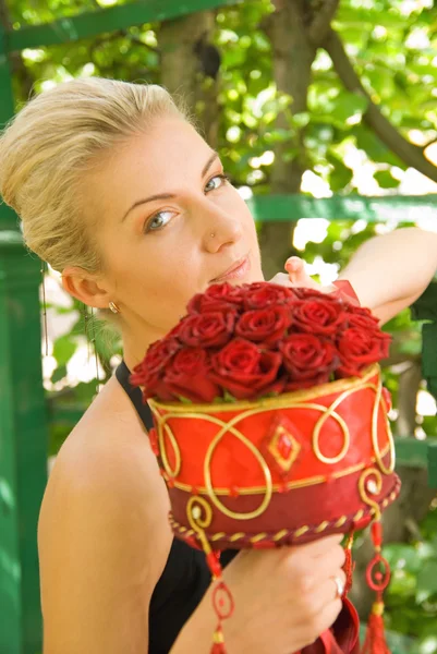 Menina loira bonita com um buquê de rosas vermelhas — Fotografia de Stock