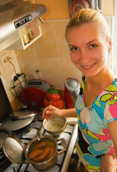 Pretty young girl cooks dinner in the kitchen — Stock Photo, Image