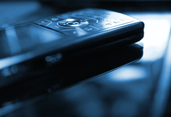 Blå tonad bild av en mobiltelefon (grunt dof, fokuserade på ro — Stockfoto