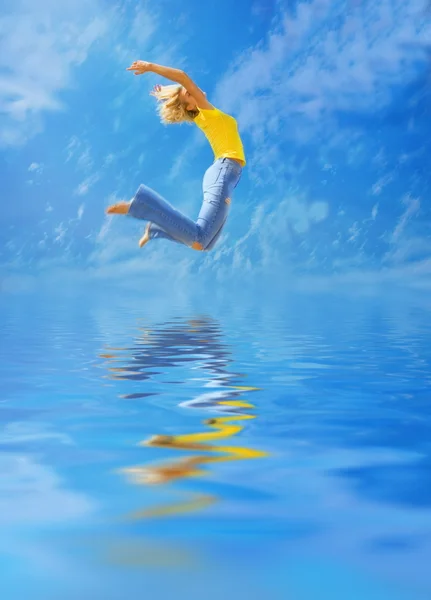 Menina loira bonita salta sobre a água — Fotografia de Stock