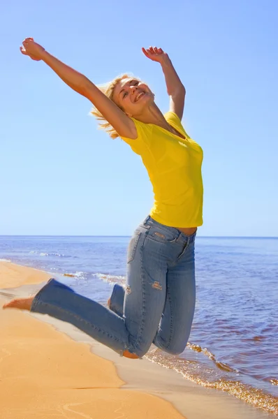 Schöne Mädchen springt auf einen Strand — Stockfoto