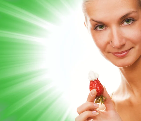 Mädchen mit einer Erdbeere auf abstrakt grünem Hintergrund — Stockfoto