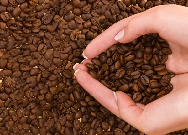 心用咖啡豆上面的手的形状 — 图库照片
