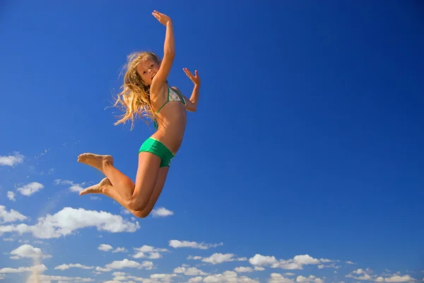 Lilla flickan hoppar i himlen Stockfoto