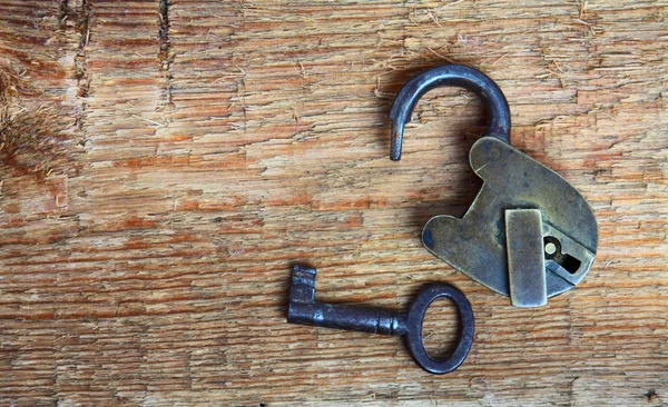 Oude hangslot en sleutel op hout Stockfoto