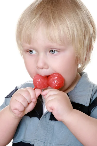 Αγόρι με ένα ριγέ γιλέκο με μια καραμέλα ζάχαρη — Φωτογραφία Αρχείου