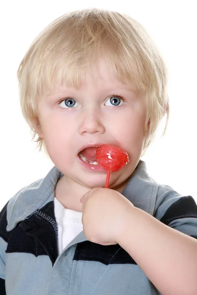 Boy in a striped vest with a sugar candy — Stock Photo, Image