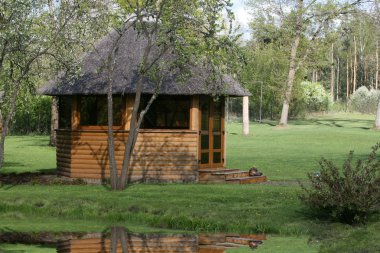 Wooden arbour on the bank of lake clipart