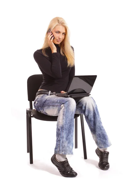 Rubia con un portátil y un teléfono sobre un fondo blanco Imágenes de stock libres de derechos
