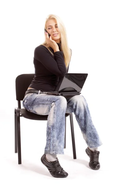 Blondin med en bärbar dator och en telefon på en vit bakgrund Royaltyfria Stockfoton
