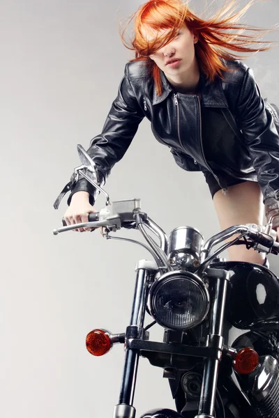 Roodharige meisje op een motorfiets — Stockfoto