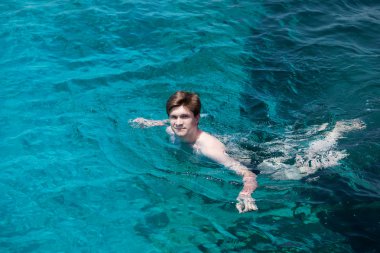 genç adam denizde yüzüyor.