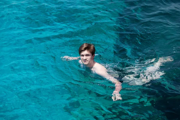 Young man swims in the sea.