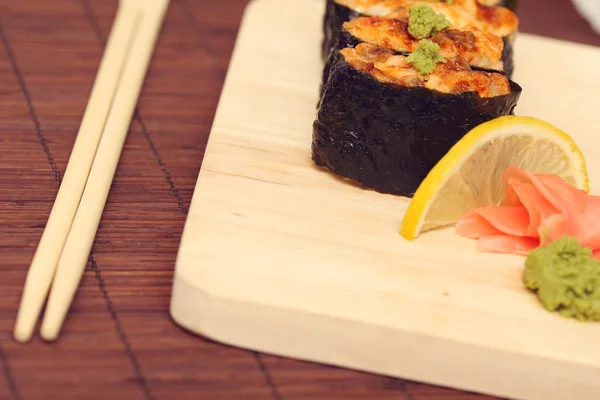 Stock image Sushi and rolls on the wooden plate